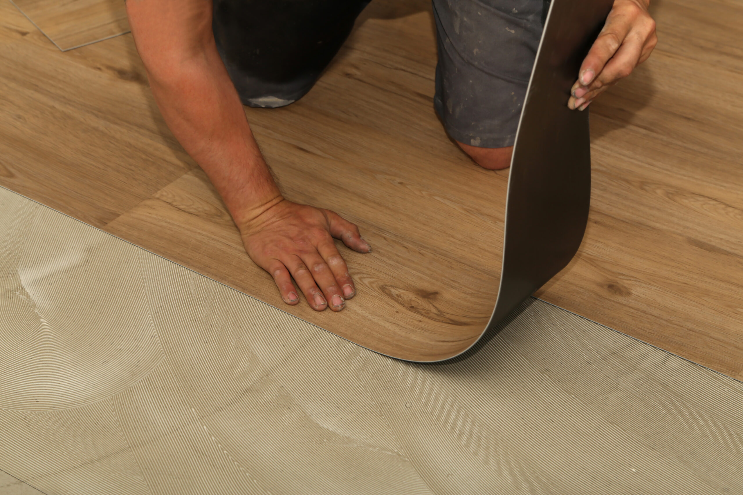 Worker installing new vinyl tile floor