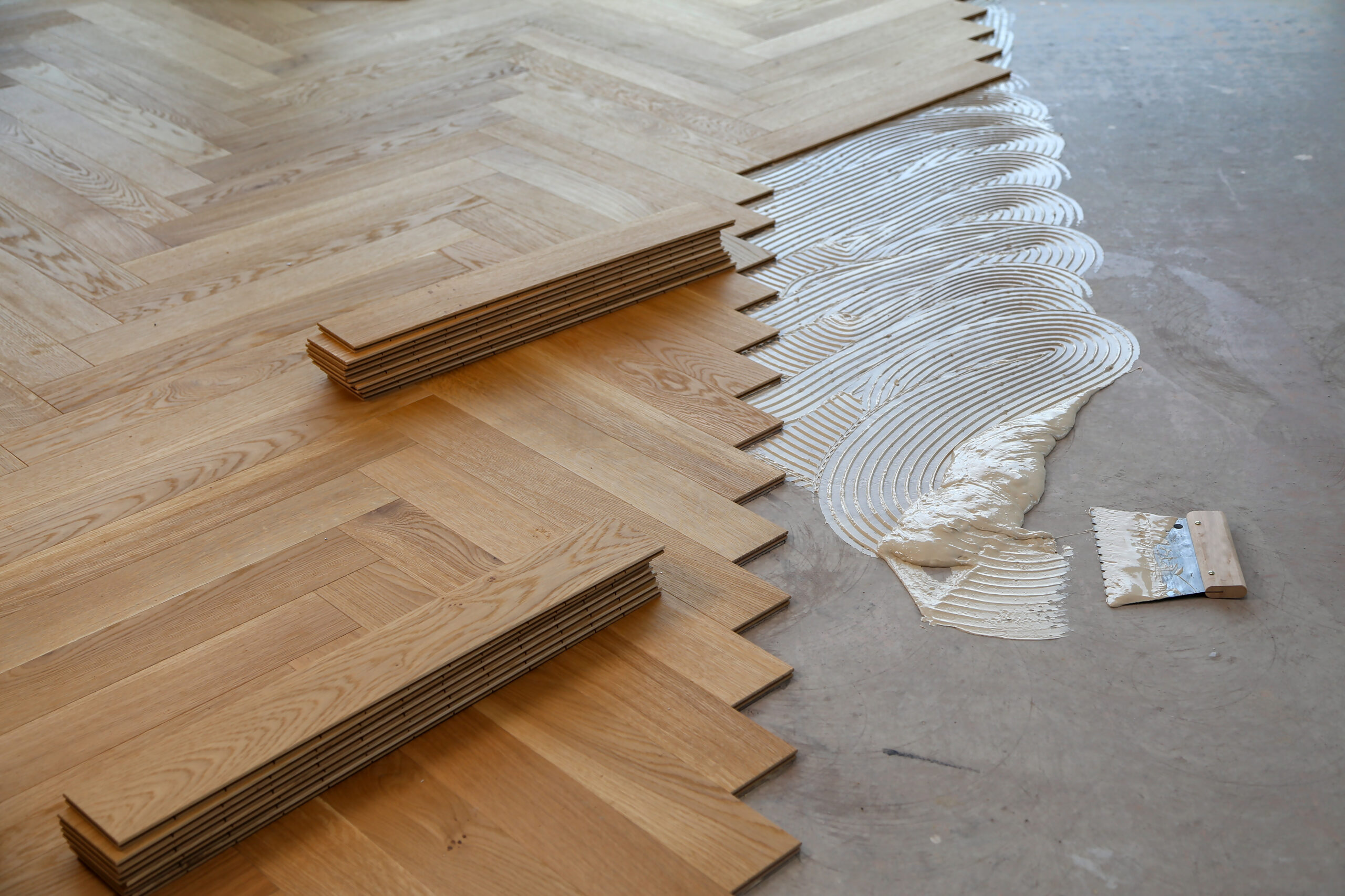 A worker laying parquet flooring and installing wooden laminate